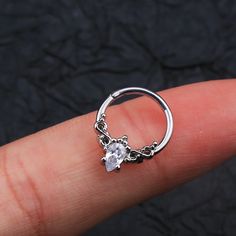 a person's finger with a ring on it that has a diamond in the middle