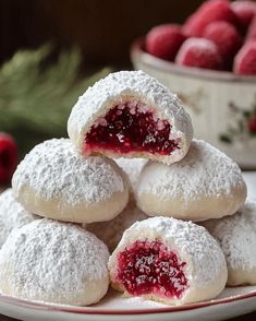 powdered sugar cookies with raspberry filling on a plate