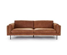 a brown leather couch sitting on top of a white floor next to a black metal frame