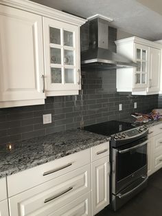 a kitchen with marble counter tops and white cabinets