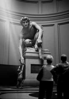 a man standing next to a statue in a room