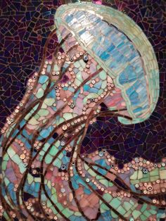 a close up view of a mosaic glass piece with beads on it's head