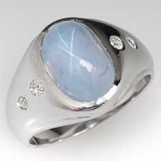 This awesome ring is centered with one (1) oval cabochon cut star sapphire set into a bezel. The shoulders of the ring are each accented with two (2), flush set, round single cut diamonds. The ring measures 13.7mm at the top, rises 8.4mm above the finger, tapering to 4.1mm wide and 1.0mm thick at the base of the shank. This ring is currently a size 6.75. Oval Diamond Cabochons With Polished Finish, Anniversary Diamond Cabochon, Modern Formal Opal Ring With Cabochon, Modern Formal Cabochon Opal Ring, Formal Modern Opal Cabochon Ring, Formal Polished Finish Oval Cabochon Sapphire Ring, Classic Formal Cabochon Moonstone Ring, Oval Cabochon Sapphire Ring With Polished Diamond, Oval Cabochon Sapphire Ring With Diamond