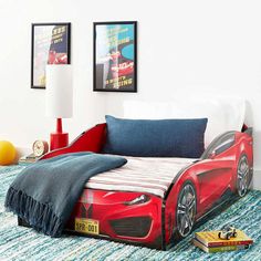 a child's bed with a red sports car design on the headboard and foot board