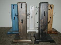 four different colored wooden pieces with hooks on them