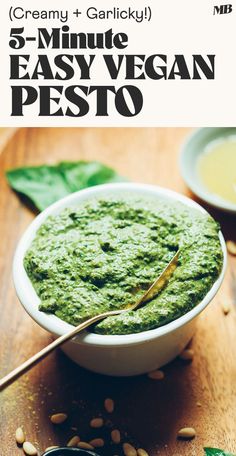 a white bowl filled with pesto on top of a wooden table