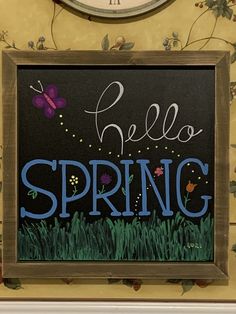 a chalkboard with the words hello spring painted on it in front of a clock