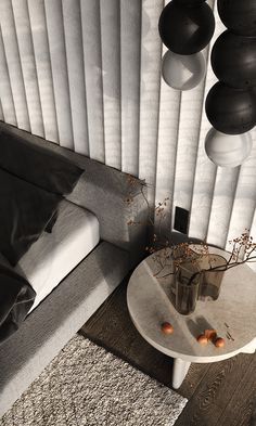 a white table sitting next to a window covered in black and white curtains on top of a wooden floor