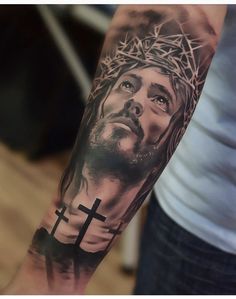 a man's arm with a tattoo of jesus and a cross on the side