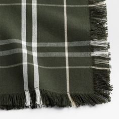 a green and white plaid blanket with fringes