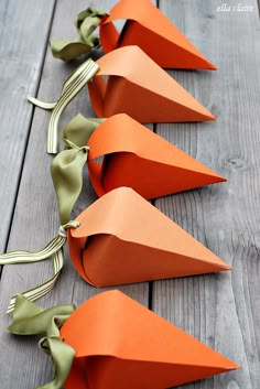 some paper cones are lined up on a wooden table with ribbons tied around them and the words easter carrot treat boxes