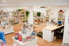 a room filled with lots of toys and bookshelves next to a desk in front of a computer