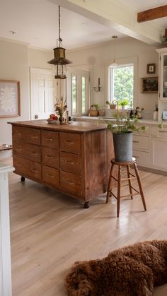 a dog laying on the floor next to a counter in a kitchen with an island