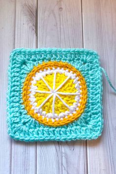 a crocheted square with an orange on it