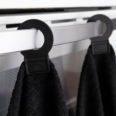 two black towels hanging on the side of a window