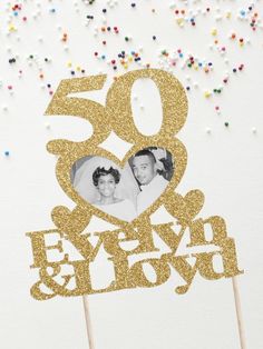 a 50th birthday cake topper with an image of two people on it and sprinkles