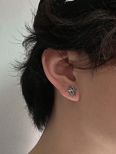 a close up of a person wearing a pair of ear piercings on their ears