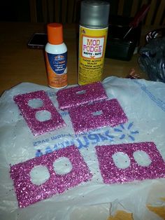 there are pink glitter letters on the table next to some glue and other crafting supplies