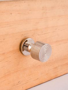 a door handle on the side of a wooden cabinet with metal spirals and knobs