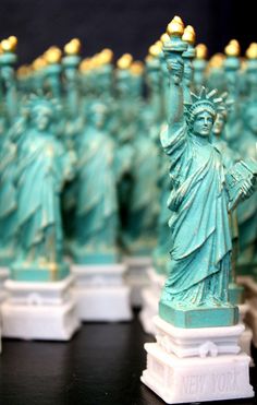 the statue of liberty is on display in front of other figurines that are lined up