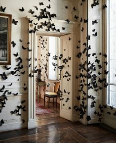 a room filled with lots of black bats flying through the air