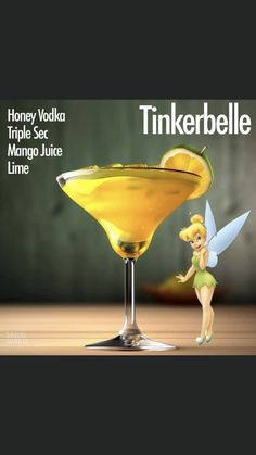 a glass filled with liquid and a tinkerbell sitting on top of it