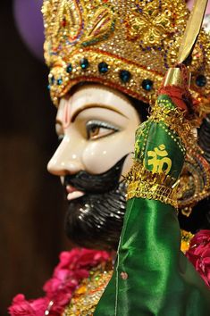 an elaborately decorated mask is held by a person