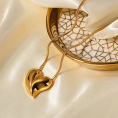 Our Embrace Heart Pendant Necklace is a symbol of enduring love, plated in sumptuous 18k gold for an everlasting shine. Its waterproof stainless steel composition ensures it is as resilient as it is beautiful. Designed to stand out, the heart pendant is a graceful twist on a classic shape, making it the perfect centerpiece for any outfit. And for those who adore a complete look, this necklace pairs seamlessly with our matching Embrace Heart Earrings, each reflecting the light and love you carry within. Heart Shaped Pendant Necklace, Rhinestone Statement Necklace, Golden Jewelry, Waterproof Jewelry, Heart Shape Pendant, Feather Necklaces, Faux Pearl Necklace, Turquoise Pendant, Metal Necklaces