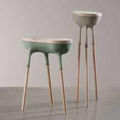 two small stools with wooden legs on the floor