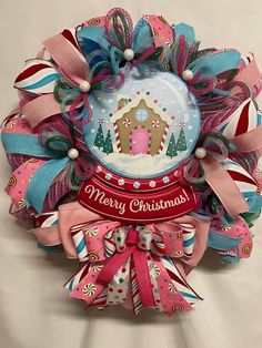 a colorful christmas wreath with a gingerbread house on the front and candy canes around it