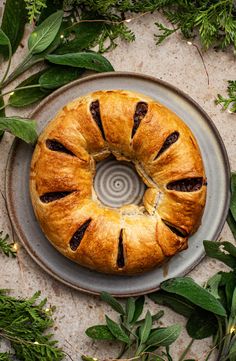 a pastry on a plate surrounded by greenery