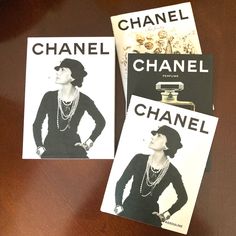 two chanel brochures sitting on top of a wooden table