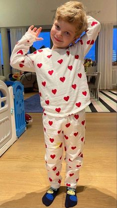 a young boy wearing pajamas with hearts on them