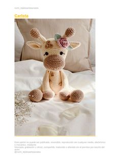 a stuffed giraffe sitting on top of a bed