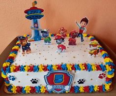 a birthday cake with paw patrol figures on it