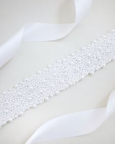 A statement sash is encrusted with beautiful pearls attached on bridal white double-faced satin ribbon. This classic pearly belts creates a romantic finishing touch to your bridal gown, bridesmaids and flower girls, or as hair accessories. DETAIL:Adult Size 108"Kids Size 78"Applique size: 12" length, 2" wideHANDMADE IN USAIMPORTED MATERIALS Accessories Matching, Women's Sash, Accessories For Wedding, Applique Wedding, Wedding Sash, Shoes Collection, Flower Girls, Bridal Gown, Satin Ribbon