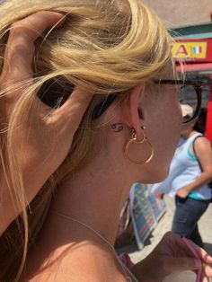 a woman wearing large gold hoop earrings on her left ear and looking off into the distance