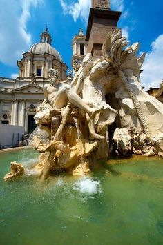 a fountain in front of a building with a clock tower