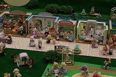 a group of toy figurines on display in front of a doll's house