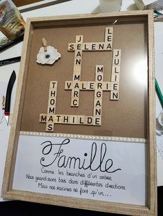 a family scrabble is displayed in a frame on a table with other items