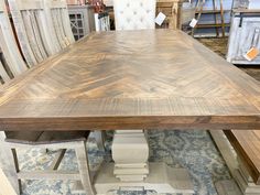 a large wooden table sitting on top of a blue rug