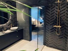 a bathroom with black and white tiles on the walls, flooring and shower stall