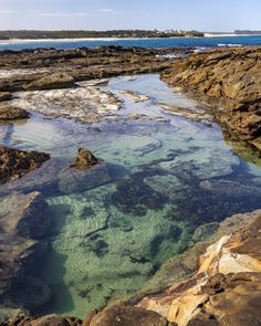 the water is crystal clear and blue in this rocky area with rocks on both sides