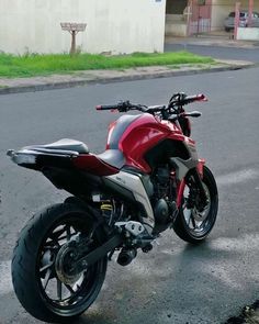 a red and gray motorcycle parked on the street