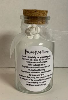 a glass jar with a poem in it and a flower on the top that says penny from heaven