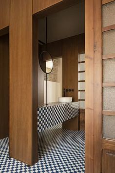 a bathroom with blue and white checkered tile on the floor next to a mirror