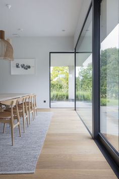 a dining room with wooden tables and chairs next to glass doors that look out onto the outdoors