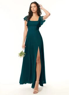 a woman in a long green dress is posing for the camera with her hand on her head