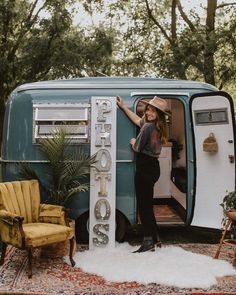 a woman is standing in the doorway of an old fashioned camper with her hand on the door