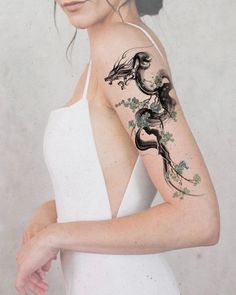 a woman with a tattoo on her arm and shoulder is looking at the camera while wearing a white dress